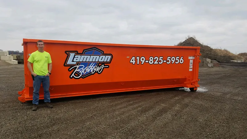 Orange15 yard dumpster for rent in Toledo, Ohio, positioned on a clean surface. A man stands adjacent to the dumpster to visually display its size and capacity. Ideal for small to medium home renovation or construction projects.